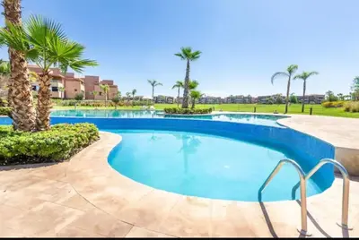 a swimming pool with palm trees in a resort at Ali plaza marrakech in Marrakech