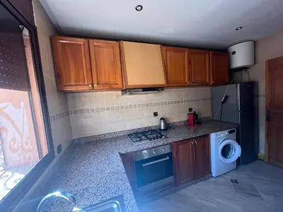 a kitchen with wooden cabinets and a washing machine at Appartement Central Marrakech in Marrakech