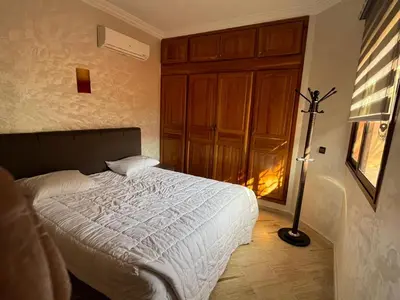 a bedroom with a bed and a lamp in it at Appartement Central Marrakech in Marrakech