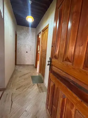 an empty room with a wooden door and a hallway at Appartement Central Marrakech in Marrakech