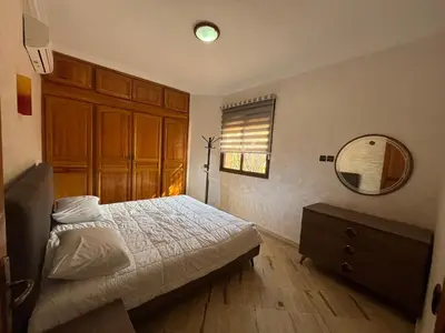 a bedroom with a bed and a mirror and a dresser at Appartement Central Marrakech in Marrakech