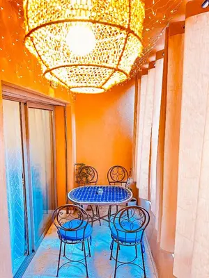 a table and chairs sitting under a chandelier at Appartement cosy Marrakech in Marrakech