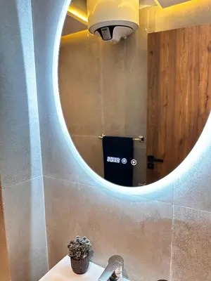 a bathroom with a round mirror above a sink at Appartement cosy Marrakech in Marrakech