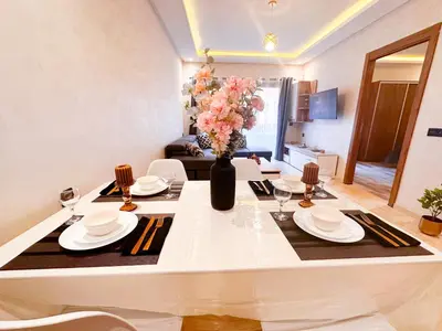 a living room with a table with a vase of flowers at Appartement cosy Marrakech in Marrakech