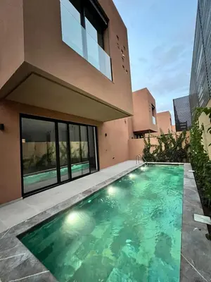 a swimming pool in front of a house at Villa Tagana in Marrakech