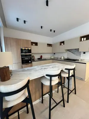 a kitchen with a large table and stools at Villa Tagana in Marrakech