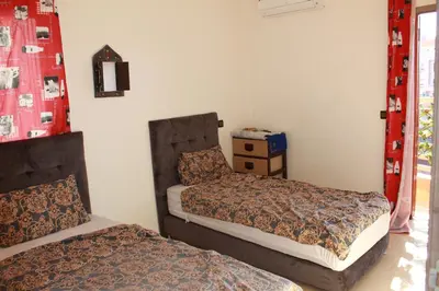 a bedroom with two beds and a dresser in it at beautiful appartement near airport in Marrakech