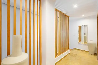 a room with a vase and a wall with stripes at Duplex Le Majorelle, Res devant le jardin, piscine in Marrakech