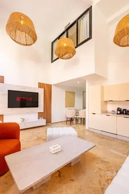a living room with a table and a kitchen at Duplex Le Majorelle, Res devant le jardin, piscine in Marrakech