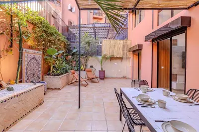 an outdoor patio with a table and chairs at Duplex Le Majorelle, Res devant le jardin, piscine in Marrakech