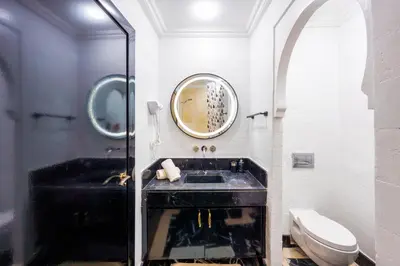 a bathroom with a black sink and a mirror at Exclusive Stay M-Avenue Marrakech in Marrakech