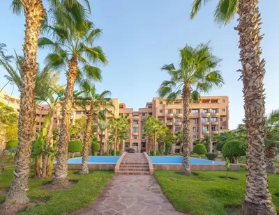 a resort with palm trees and a pathway at Exclusive Stay M-Avenue Marrakech in Marrakech