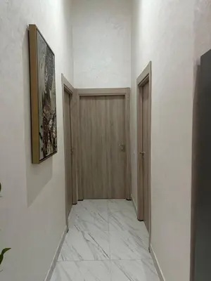 a hallway with two doors and a tile floor at La Citrine appartement de haut standing in Marrakech