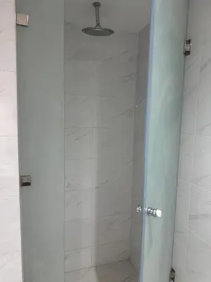 a shower with a glass door in a bathroom at La Citrine appartement de haut standing in Marrakech
