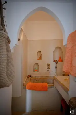 a bathroom with a bath tub and an archway at Riad Bacha Beldi in Marrakech