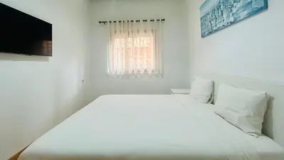 a white bed in a room with a window at le saphir un appartement de paradis in Marrakech