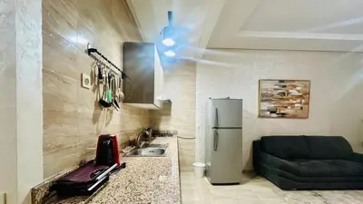 a kitchen with a sink and a refrigerator at le saphir un appartement de paradis in Marrakech
