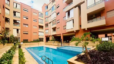 an apartment complex with a swimming pool and buildings at le saphir un appartement de paradis in Marrakech