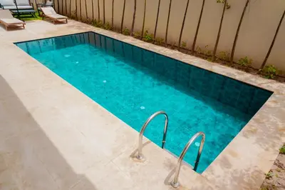 a swimming pool with blue water in a backyard at Villa émeraude - Route Ourika in Marrakech