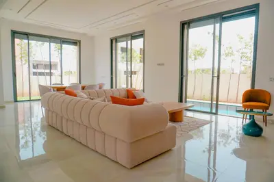 a living room with a couch and tables and windows at Villa émeraude - Route Ourika in Marrakech