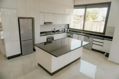 a kitchen with white cabinets and a black counter top at Villa émeraude - Route Ourika in Marrakech