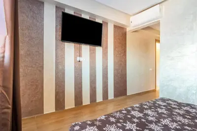 a room with a flat screen tv on a wall at Wonderful apartment with garden and large pool in Marrakech