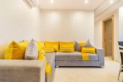 a living room with a couch with yellow pillows at Wonderful apartment with garden and large pool in Marrakech