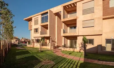 a large building with a lawn in front of it at Wonderful apartment with garden and large pool in Marrakech