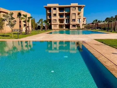 a large swimming pool in front of a building at Wonderful apartment with garden and large pool in Marrakech