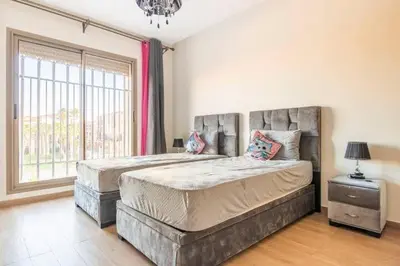 a bedroom with a large bed and a large window at Wonderful apartment with garden and large pool in Marrakech
