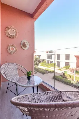a patio with a table and chairs and a window at Mya cosy - Clim, Wifi, Jardin à 10min de l'Aéroport in Marrakech