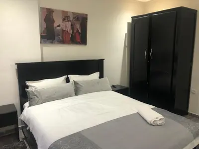 a bedroom with a large bed with white sheets and pillows at Modern apartment centre ville in Marrakech
