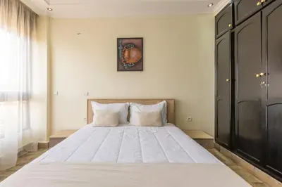 a bedroom with a large white bed with a picture on the wall at Elegant apartment downtown in Marrakech