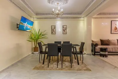 a dining room with a table and chairs and a couch at Elegant apartment downtown in Marrakech