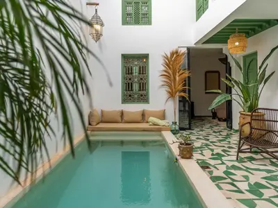a swimming pool in a house with a couch next to it at Riad Dar Victoire in Marrakech