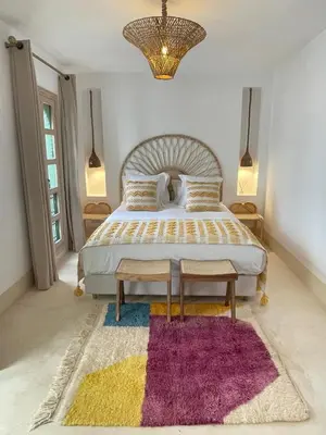 a bedroom with a large bed with a purple rug at Riad Dar Victoire in Marrakech