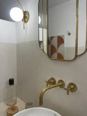 a bathroom sink with a gold faucet and a mirror at Riad Dar Victoire in Marrakech