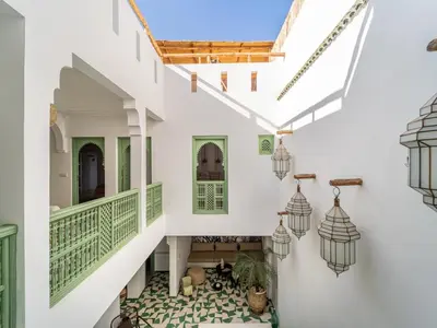 an internal view of a house with white walls and green accents at Riad Dar Victoire in Marrakech