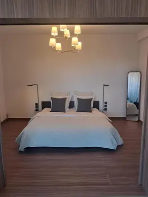 a bedroom with a large white bed and a chandelier at Magnifique appartement in Marrakech