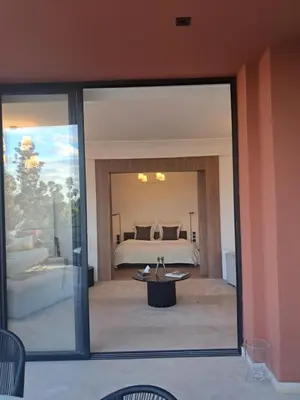 a view of a bedroom with a bed through a glass door at Magnifique appartement in Marrakech