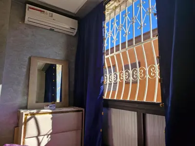 a room with a window and a refrigerator and a mirror at apprtement near the airport in Marrakech