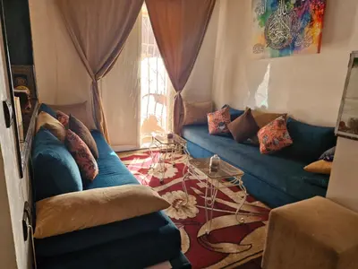 a living room with a blue couch and a window at apprtement near the airport in Marrakech