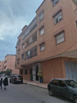 a large brick building with cars parked in front of it at apprtement near the airport in Marrakech