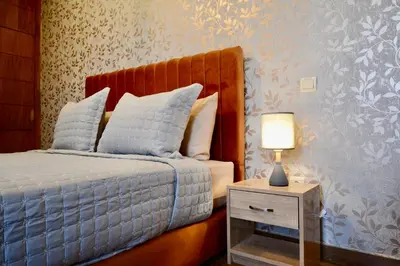 a bedroom with a bed and a nightstand with a lamp at Serenity City Center Apt in Marrakech