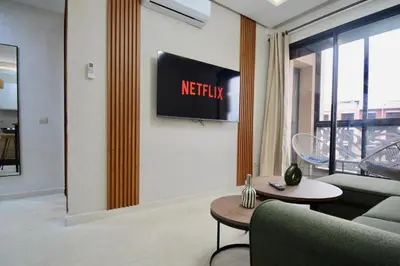 a living room with a couch and a sign on the wall at Serenity City Center Apt in Marrakech