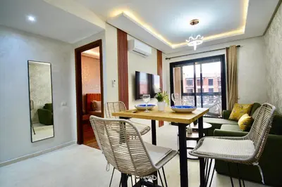 a dining room with a table and chairs and a couch at Serenity City Center Apt in Marrakech