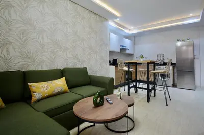 a living room with a green couch and a table at Serenity City Center Apt in Marrakech
