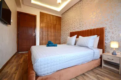 a bedroom with a bed with a blue bag on it at Serenity City Center Apt in Marrakech