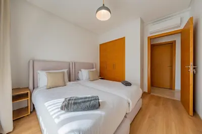 a bedroom with a large white bed with a purse on it at Modern Appart-Golf View, Terrace & Fiber Optic in Marrakech