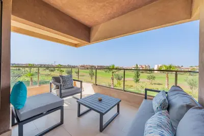 a living room with a couch and a table at Modern Appart-Golf View, Terrace & Fiber Optic in Marrakech